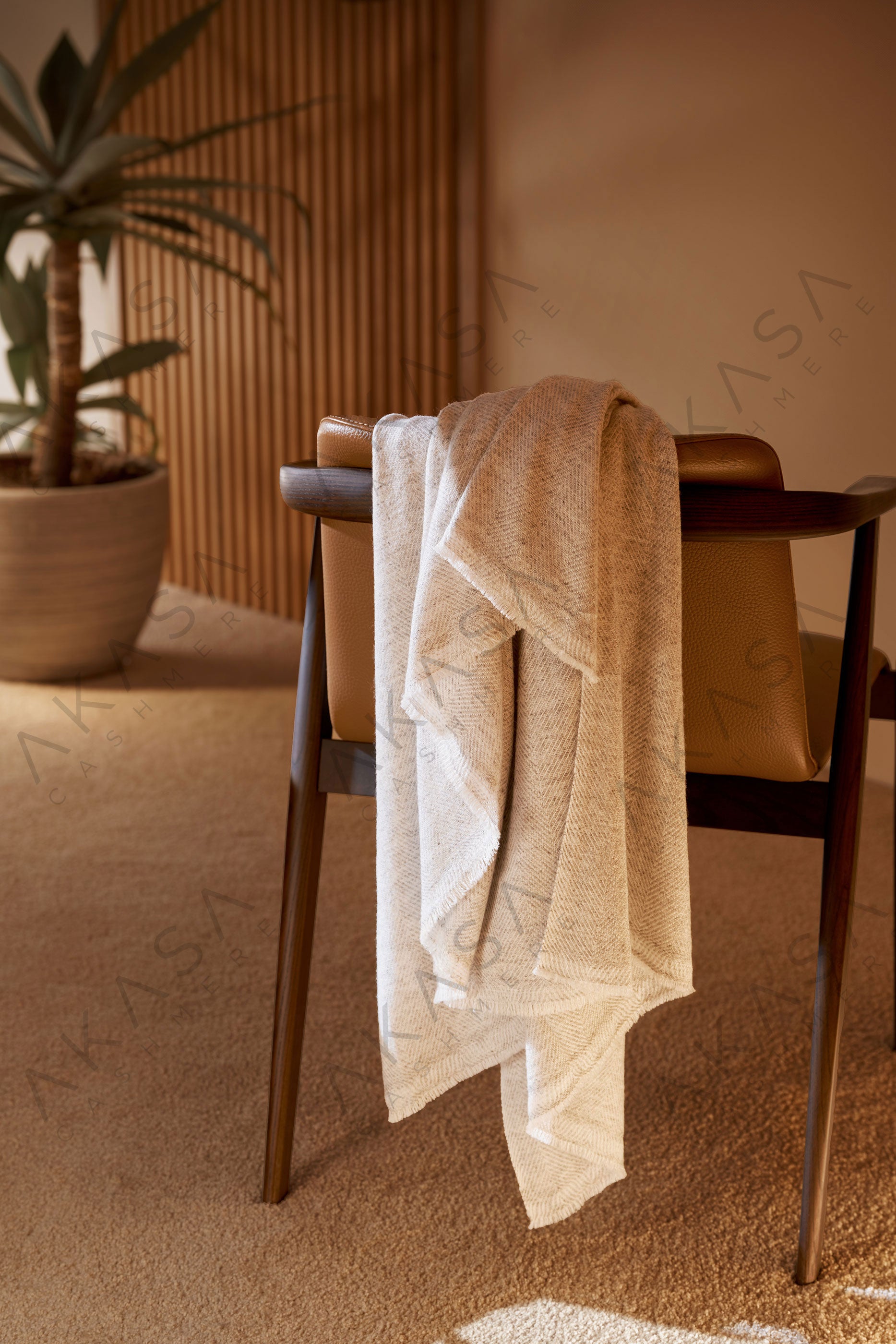 Luxury cashmere blanket styled on a sofa in a modern living room interior